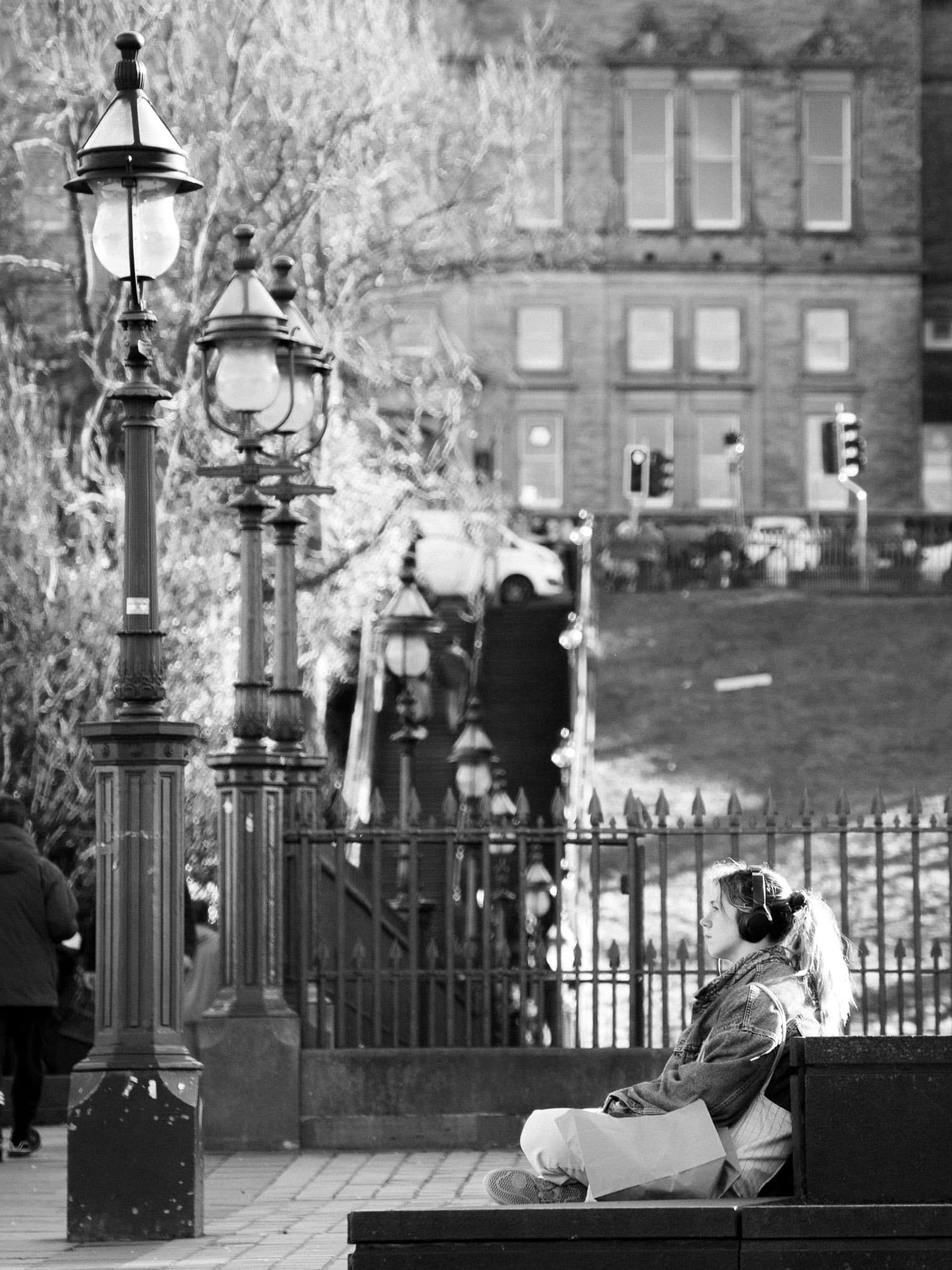 Someone sitting on some steps, taking a break, and looking off into the distance (black and white)